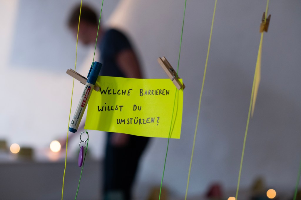 Ein gelber Zettel, auf dem steht: Welche Barrieren willst du umstürzen?