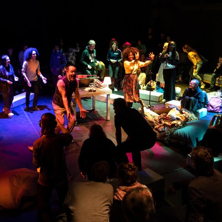 Menschen tanzen und sind beleuchtet von bunten Lichtern