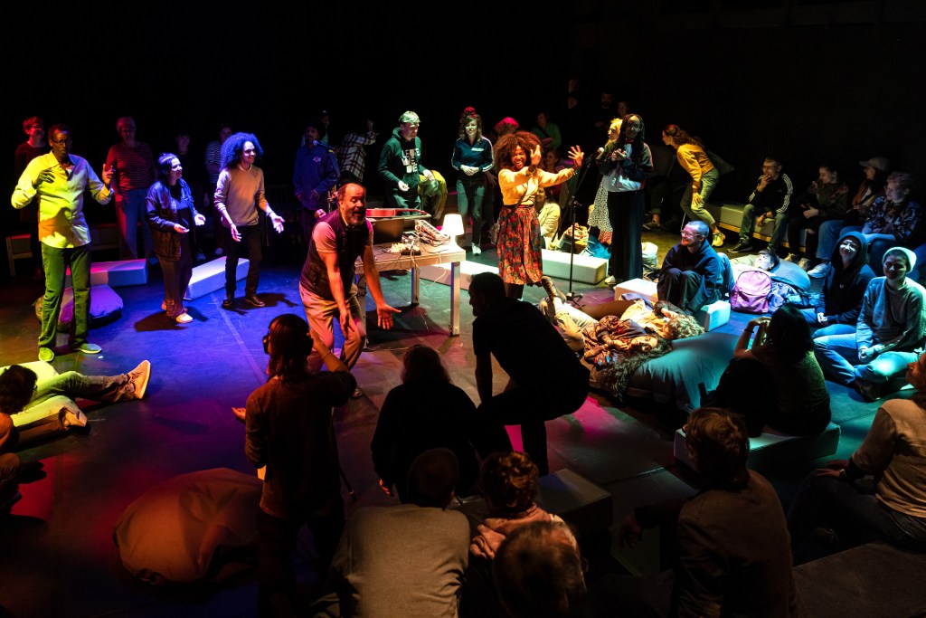 Menschen tanzen und sind beleuchtet von bunten Lichtern